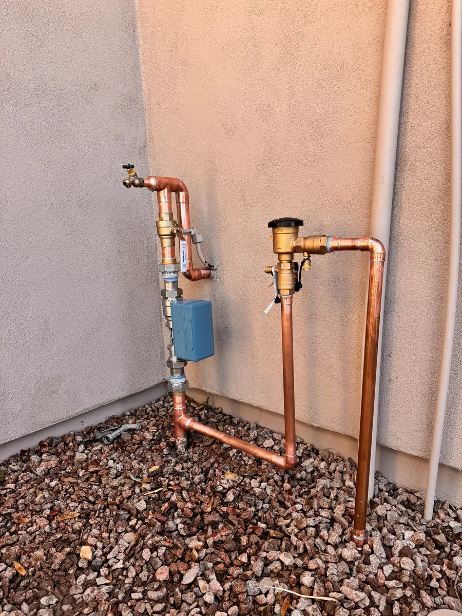 New copper water main with pressure regulator and backflow preventer on a Gilbert home