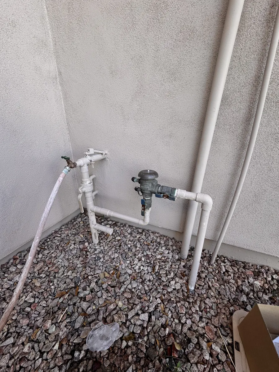 Old PVC water main and backflow preventer on a Gilbert home before replacement