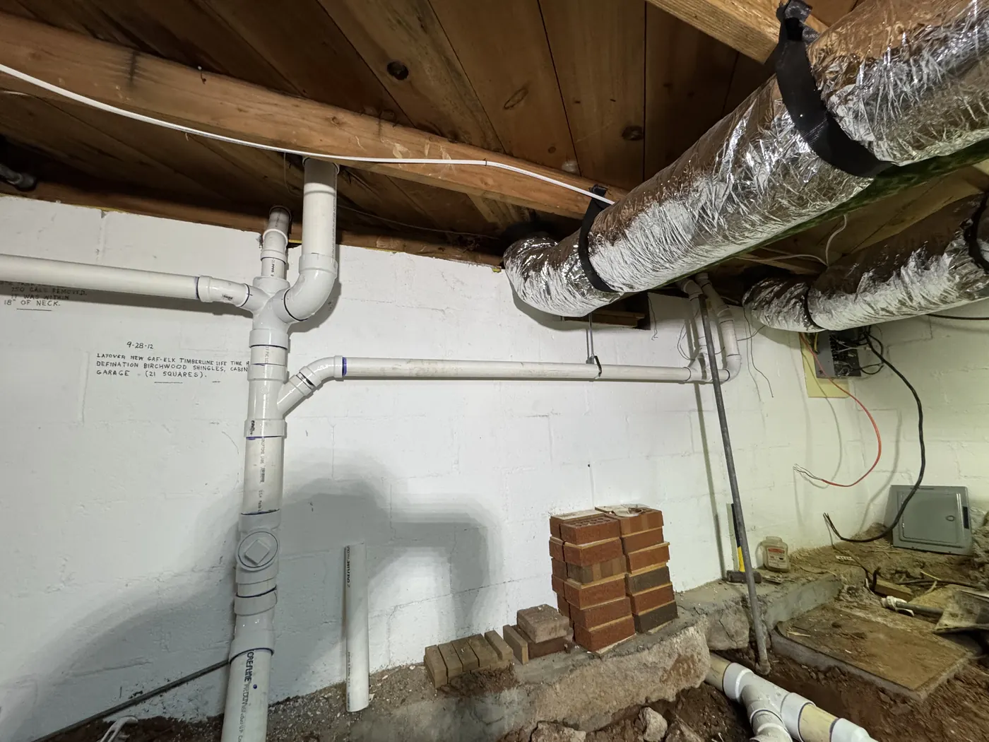New PVC drain piping with fittings run beneath a home
